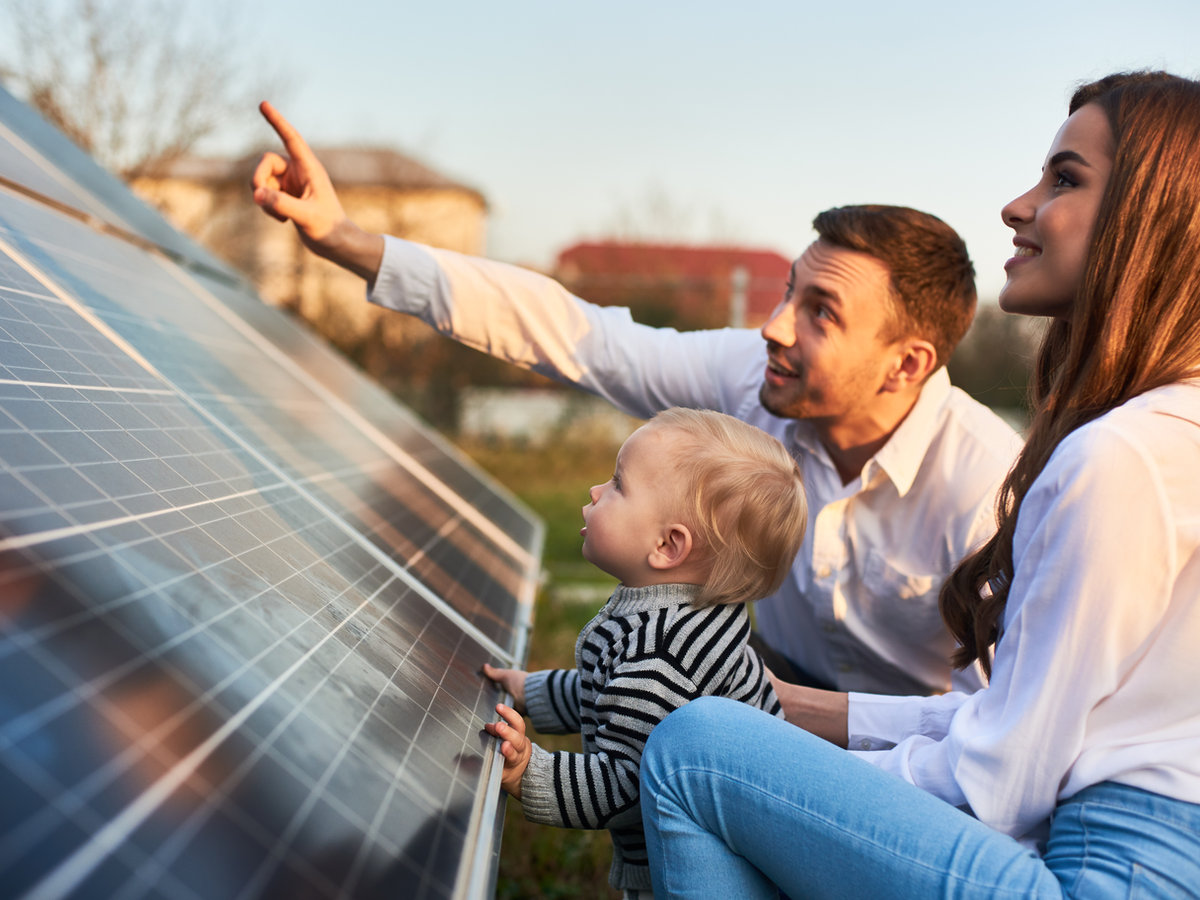 A local family looking over their newly installed solar panels at sunset